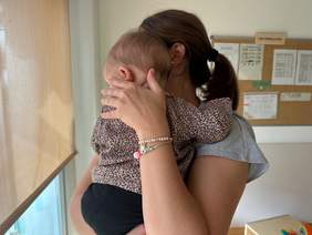 Educadora abraçant a un nadó